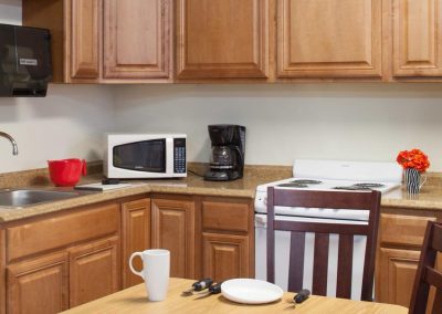 A functional kitchen area with occupation therapy tools in use on the kitchen table.