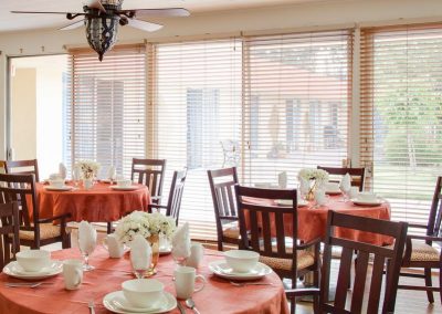 Playa del Rey center dining room with nicely set tables and fresh flowers on each table.